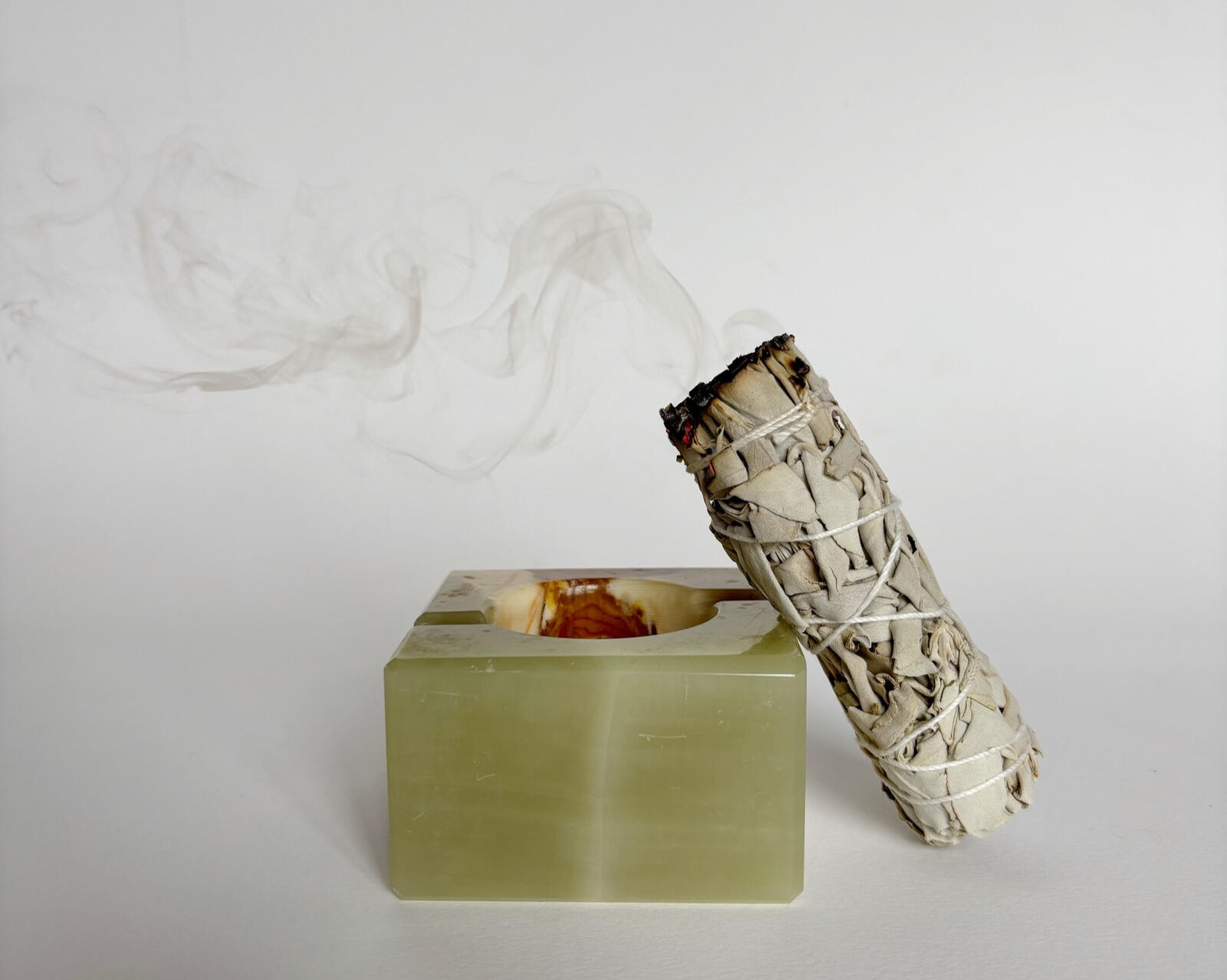Vintage Onyx Ashtray sage stick resting on a green stone holder with soft smoke