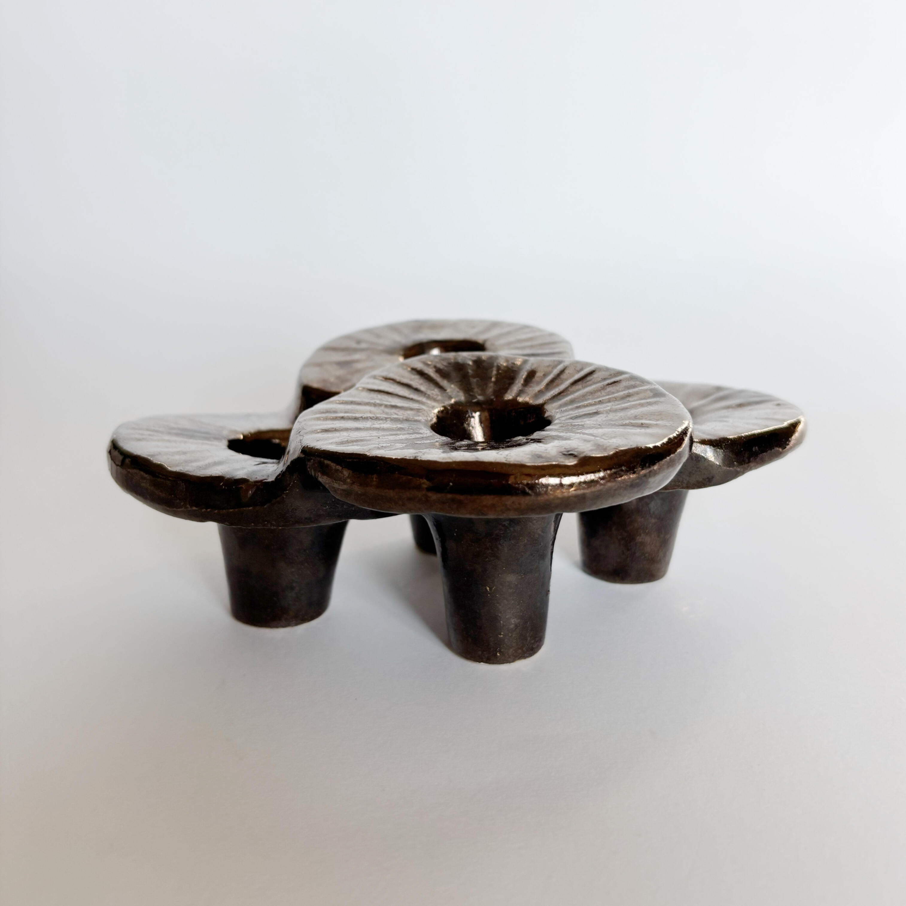 Organic sculptural form with a dark glossy glaze.